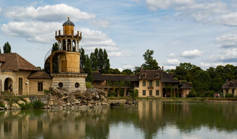 Foto: Hameau de la Reine, die Gebäude spiegeln sich im See.